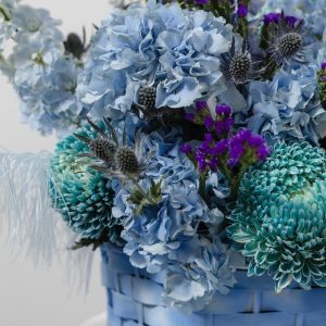 A close-up view of the luxury "Art of Blue" basket, highlighting the mix of shades of blue and delicate feathers.