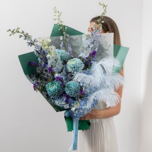 A full view of the luxury "Art of Blue" bouquet, highlighting the mix of shades of blue and delicate feathers.