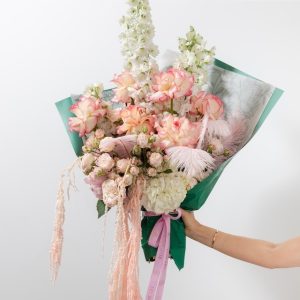 A stunning bouquet of soft pink and white flowers with real feathers and preserved amaranthus.
