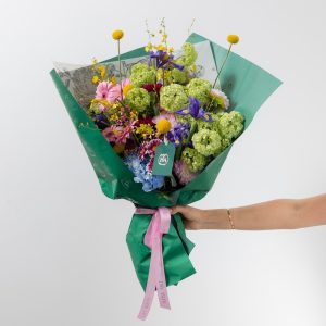 A stunning, vibrant bouquet with a mix of colorful fresh flowers, including blue hydrangeas and pink gerberas.