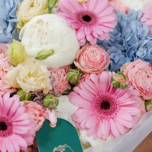 A close-up view of the "Cotton Candy" bouquet, showing the detail of the white peonies and pink gerberas.