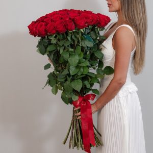A close-up side view of the Red Naomi roses, showcasing their velvety petals and long stems.