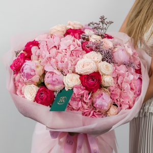 A large, beautiful bouquet of pink peonies, hydrangeas, and various roses.
