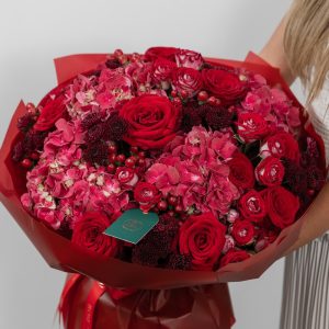 A large, beautiful bouquet of red and dark pink roses, hydrangeas, and chrysanthemums.