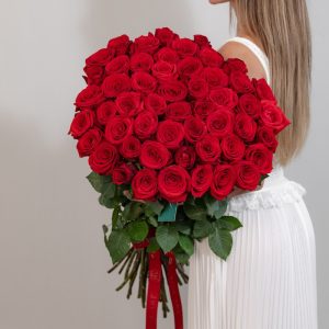 A stunning bunch of fresh, long-stemmed red Naomi roses on a white background.