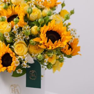 A close-up view of the luxury Sunshine box, highlighting the intricate mix of sunflowers and yellow spray roses.