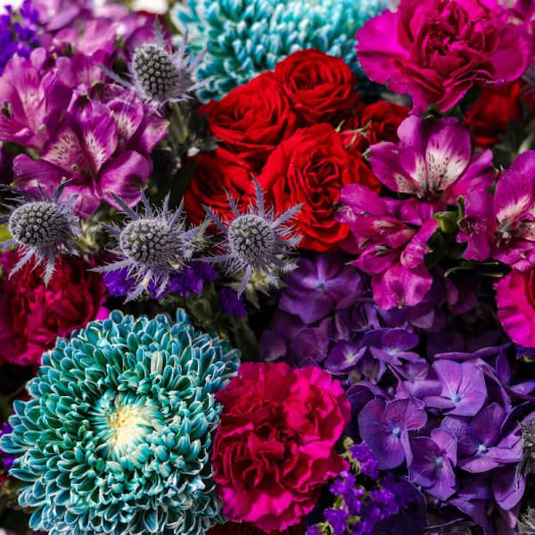 An angled view of the Midnight Bloom basket, showcasing the flowers and the rustic charm of the basket.