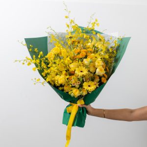 A stunning all-yellow bouquet of fresh flowers, including gerberas, roses, chrysanthemums, and oncidium orchids.