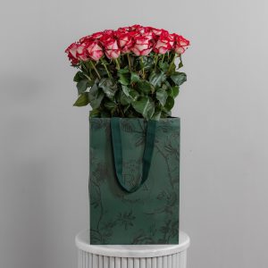 A large bunch of B-tween roses arranged in a tall, elegant glass vase, ready to be displayed in a home or office setting.