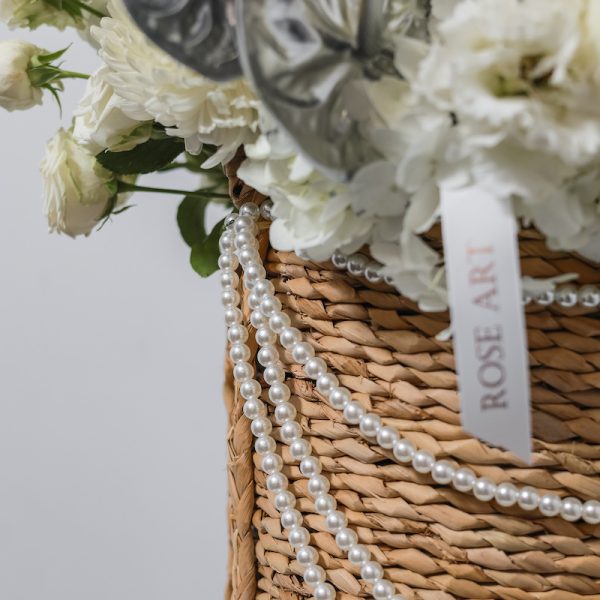 A close-up side view of the Star White basket, showing the detail of the fresh white blooms and greenery.
