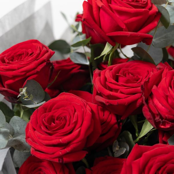 A close-up side view of the Aroma bouquet, showing the detail of the Red Naomy roses and the eucalyptus leaves.