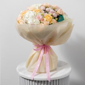 A close-up side view of the Dusky Bloom bouquet, showing the detail of the peach avalanche roses.