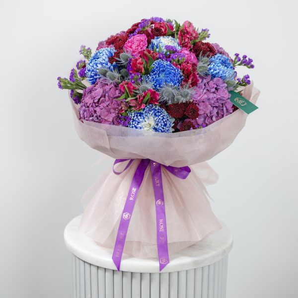 A close-up side view of the Midnight Bloom bouquet, showing the mix of dark-toned blooms.