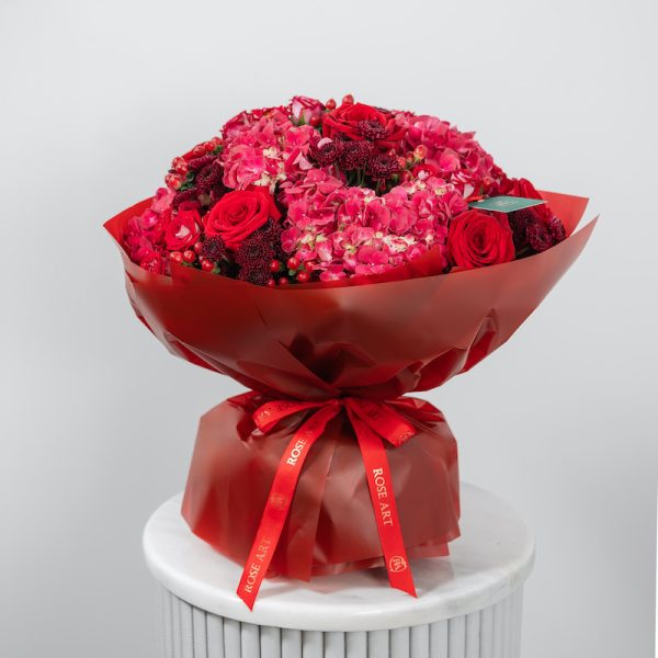 A close-up side view of the Red Classic bouquet, showing the mix of red roses and pink hydrangeas.