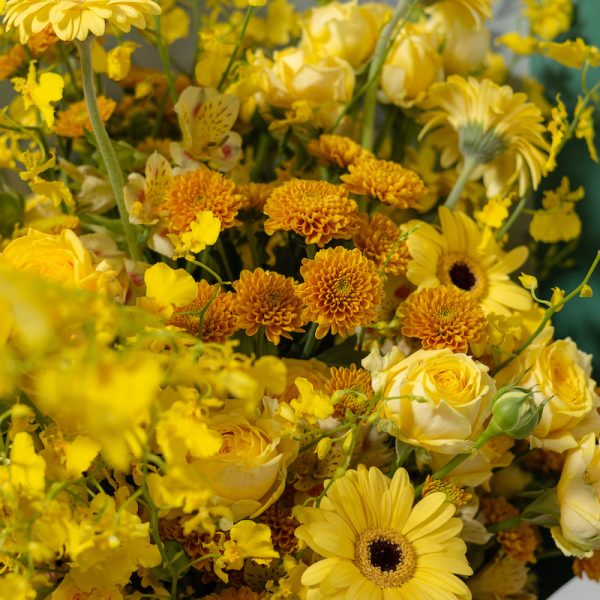 A close-up side view of the Art of Yellow bouquet, showing the detail of the gerberas, roses, and chrysanthemums.