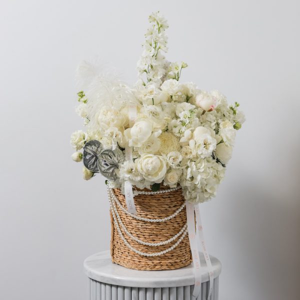A stunning white flower basket arrangement with a mix of fresh blooms and silver accents.