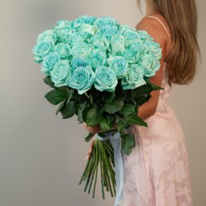A stunning, full bunch of fresh, long-stemmed Tiffani blue roses, tinted to a vibrant sky blue color, arranged against a clean background.